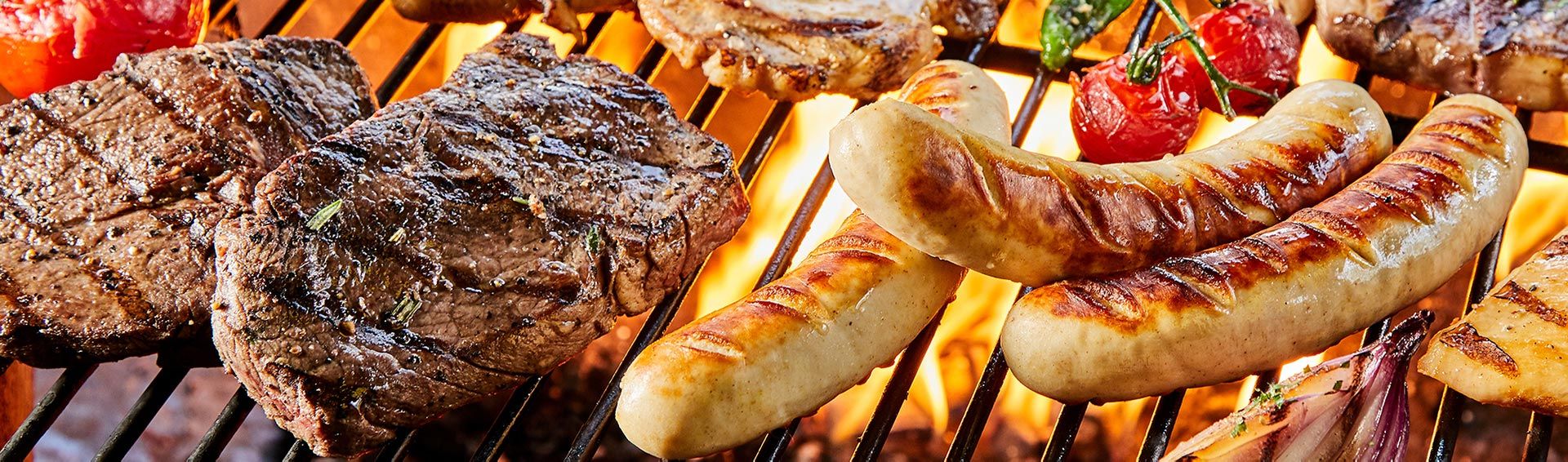 Mariniertes Grillfleisch über offenen Flammen – saftig brutzelnd mit Kräutern und Gewürzen, inszeniert für echte Grillmomente.